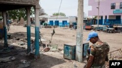 A United Nations peacekeeper looks at the destruction in Malakal on March 4, 2014. 