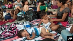 A group of migrants rests at the central park in Ciudad Hidalgo, Mexico, Oct. 20, 2018. 