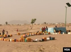 FILE - Refugees set out containers waiting for UNHCR to fill them with water, at Minawao refugee camp, northern Cameroon, Feb. 9 2018. (M. Kindzeka/VOA)