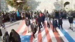 Algunas personas caminan sobre las banderas de Estados Unidos e Israel en la Universidad Shahid Beheshti de Teheran el 12 de enero de 2020, mientras que otras dan la vuelta alrededor, en esta foto de Reuters tomada de un video en las redes sociales.