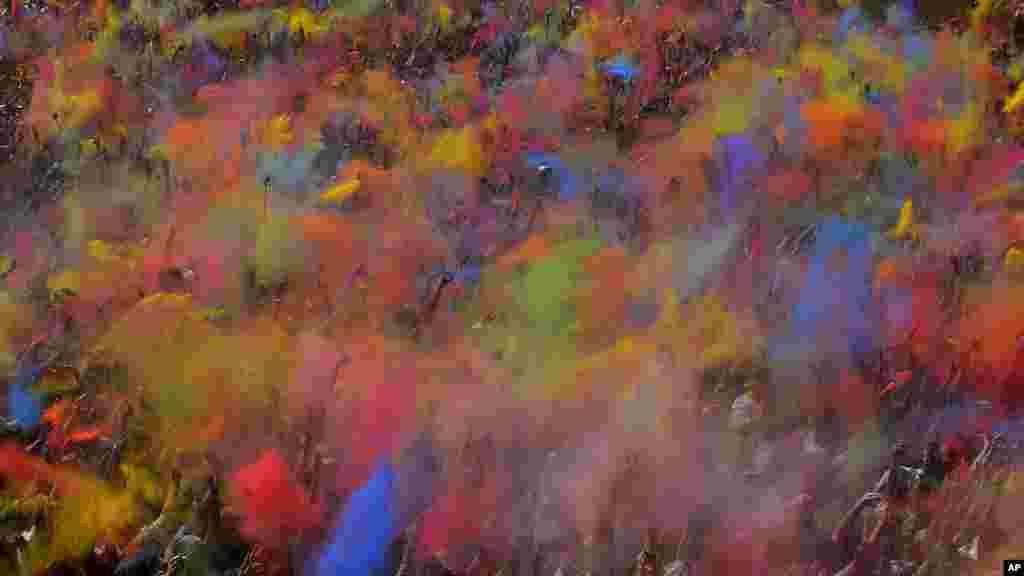 Les visiteurs du Festival des couleurs Holi jettent de la poudre spéciale colorée dans l&#39;air, à Barcelone, Espagne, dimanche 6 Avril 2014. 