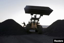FILE : A driver gets off a loading vehicle at a small coal depot near a coal mine on the outskirts of Jixi, in Heilongjiang province, China, Oct. 23, 2015.
