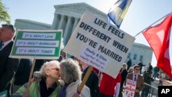 Shelly Bailes, 74, left, and her wife, Ellen Pontac, 73, of Davis, Calif., kiss in front of the Supreme Court in Washington, where justices were hearing arguments in same-sex marriage cases, April 28, 2015. (AP Photo/Cliff Owen)