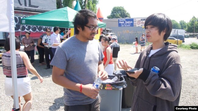 left, is seen listening to a local resident at a BBQ gathering, Seattle, August 19, 2017. (Courtesy of Sameth Mell)