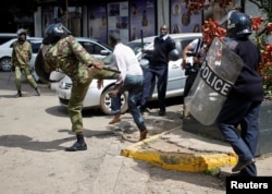 Kenyan policemen beat a protester during clashes in Nairobi, May 16, 2016.