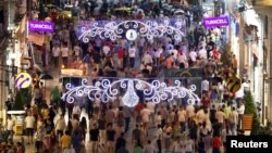 People walk along a main shopping street of Istiklal in Istanbul, Turkey, July 11, 2012. 