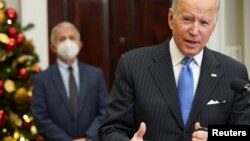 Predsjednik Joe Biden obraća se javnosti sa informacijama o omicronu, novom soju koronavirusa, dok doktor Anthony Fauci sluša u pozadini. (Foto: Reuters/Kevin Lamarque)
