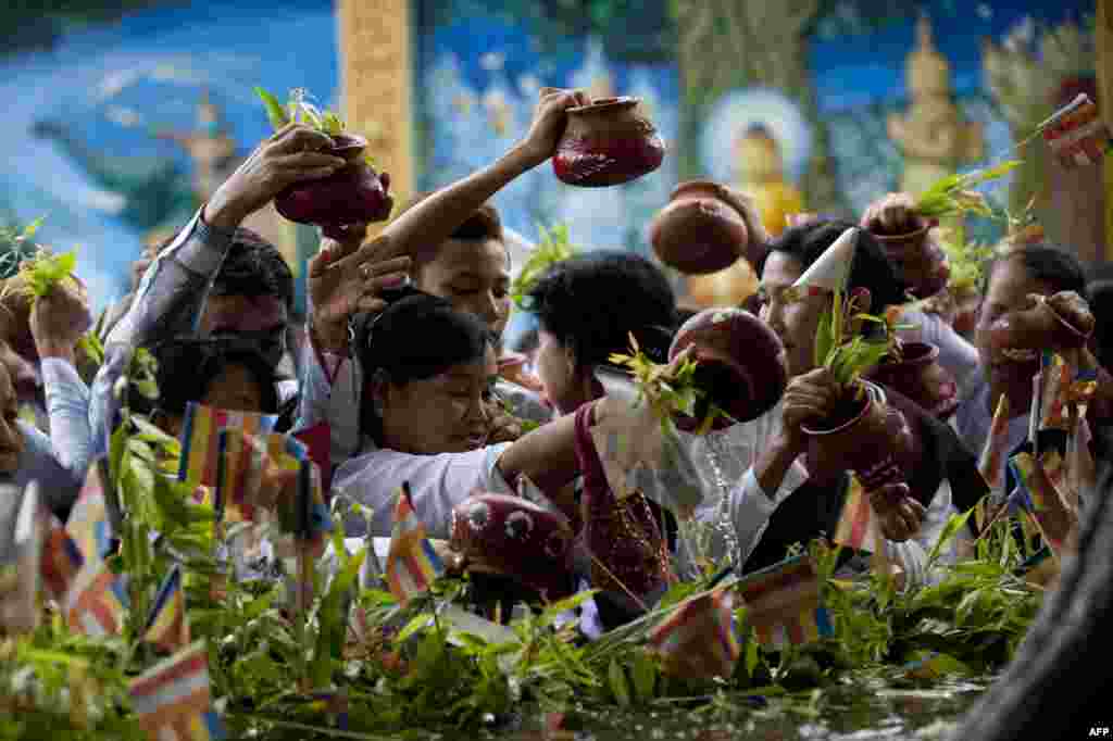 Para perempuan Buddha menyiramkan air ke pohon keramat dalam upacara keagamaan di pagoda Shwedagon, di Rangoon, Burma, untuk memperingati kelahiran Buddha Gautama.