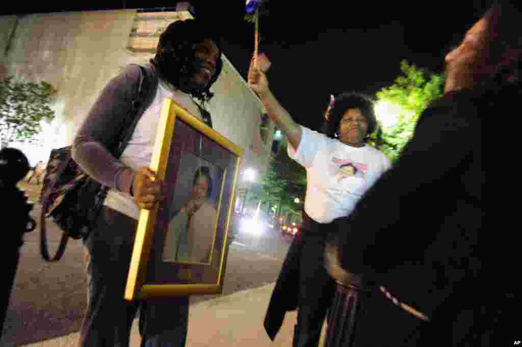 A pair of women honor their aunt, Cecelia E. Richard, who was killed in the September 11 attacks on the Pentagon, by carrying her picture amongst revelers near the White House after U.S. President Barack Obama announced that U.S. authorities have recovere