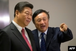 FILE - Chinese President Xi Jinping, left, is shown around the offices of Chinese tech firm Huawei technologies by its President Ren Zhengfei in London during his state visit, Oct. 21, 2015.
