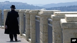 An ultra-Orthodox Jewish man walks in Ramat Shlomo, a religious Jewish settlement in an area of the West Bank annexed to Jerusalem by Israel. Israel's interior minister has given final approval for a plan to build 1,600 settler homes in the East Jerusalem