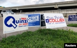 Political campaign signs stand outside a polling station in Austin, Texas, March 5, 2018, ahead of the first statewide U.S. primary of the year.