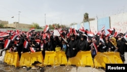 FILE - Followers of Iraq's Shi'ite cleric Muqtada al-Sadr wave Iraqi flags during a protest demanding that parliament approve a long-delayed new cabinet, in Baghdad, Iraq, April 26, 2016. The protests have since subsided.