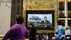 People look at a sign from Donald Trump's television show, "The Apprentice," in New York on March 27, 2004