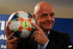 FILE - FIFA President Gianni Infantino holds the official ball of the upcoming Women's Soccer World Championship as he poses for photographers during a press conference at the end of an executive committee meeting in Rome, Feb. 27, 2019.