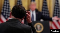 Un periodista se rasca la cabeza tras escuchar una de las respuestas del presidente de EE.UU., Donald Trump, durante una comparecencia en la Casa Blanca.