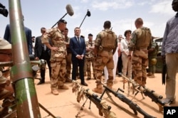 French President Emmanuel Macron, center left, visits soldiers of Operation Barkhane in Gao, Northern Mali, Friday, May 19, 2017.
