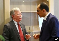 U.S. National Security Adviser John Bolton, left, and his Turkish counterpart and senior adviser to President Recep Tayyip Erdogan, Ibrahim Kalin, right, talk at the Presidential Palace in Ankara, Turkey.