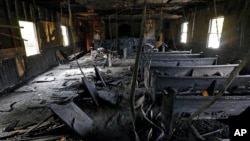 Burned pews, destroyed musical instruments, Bibles and hymnals are part of the debris inside the fire damaged Hopewell M.B. Baptist Church in Greenville, Mississippi, Nov. 2, 2016. 