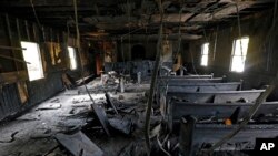 FILE - Burned pews and destroyed musical instruments, Bibles and hymnals are part of the debris inside the fire-damaged Hopewell M.B. Baptist Church in Greenville, Mississippi, Nov. 2, 2016. 