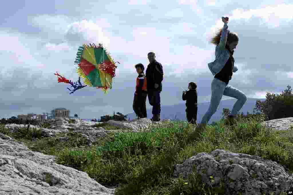 A young woman attempts to launch her kite on &#39;CleanMonday&#39; at Filopappos hill with the ancient Parthenon temple seen in the background, in Athens. Many Greeks commemorate &#39;CleanMonday&#39;, the first day of Lent, by flying kites and eating foods associated with fasting.