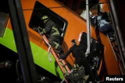 Rescuers work at a site where an overpass for a metro partially collapsed with train cars on it at Olivos station in Mexico City, Mexico May 3, 2021. REUTERS/Luis Cortes