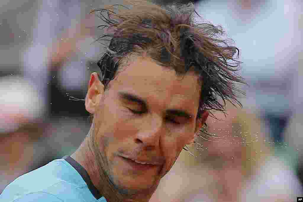 Spain&#39;s Rafael Nadal shakes the sweat off his head after winning his fourth round match of the French Open tennis tournament against Serbia&#39;s Dusan Lajovic at the Roland Garros stadium, in Paris, France. Nadal won in three sets 6-1, 6-2, 6-1.