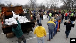 Volunteers form a human chain as they help load sandbags to battle flooding in St. Louis, Dec. 29, 2015.