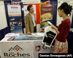 A student asks aboutLes Roches, an International School of Hotel Management, with an admission program director at the National College Fairs event in 2009.