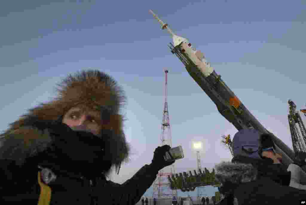 Orang-orang mengambil foto roket Rusia Soyuz-FG dengan kapsul ruang angkasa Soyuz TMA - 15M yang akan membawa kru baru ke Stasiun Luar Angkasa Internasional (ISS), pada landasan luncur di Kosmodrom Baykonur yang disewa Rusia, di Kazakhstan. Dijadualkan Misi Soyuz baru itu dimulai pada hari Senin. &nbsp;