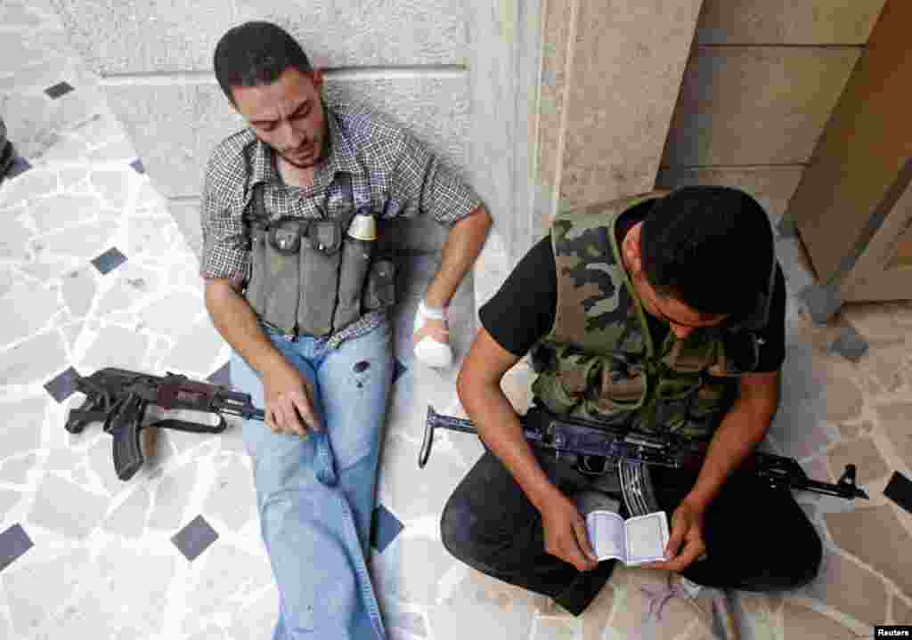A Free Syrian Army fighter reads the Quran before clashes in Aleppo, August 16, 2012.