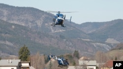 Des hélicoptères participant aux recherches à Seyne-les-Alpes, en France, sur le site du crash du Germanwings Airbus A320 (AP Photo/Claude Paris)