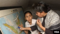 Sri Rosiyanti mengajar seorang anak perempuan di sekolah terbuka yang ia dirikan bersama saudara kembarnya Sri Irianingsih. Angka terbaru menunjukkan lebih dari lima juta perempuan Indonesia mengalami buta aksara. (foto: dok)