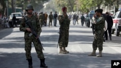 Afghanistan's National Army (ANA) soldiers stand guard at the site of an explosion on a road to the presidential palace, in Kabul, Afghanistan, Sept. 28, 2014. 