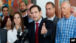 El senador Marco Rubio, centro, habla a miembros de los medios de comunicación después de que él, el senador Rick Scott, derecha, y el representante Mario Díaz-Balart, segundo desde la derecha, se reunieron con líderes de la comunidad venezolana,.