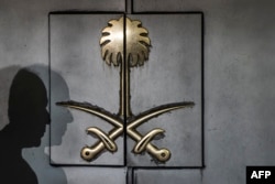 The shadow of a security guard is seen on the entrance door of the Saudi Arabia's consulate in Istanbul, on Oct. 12, 2018.