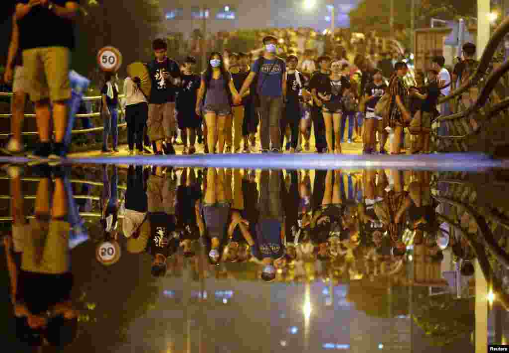 Protesters walk along a street as they block an area near the government headquarters building, in Hong Kong, Sept. 30, 2014. 