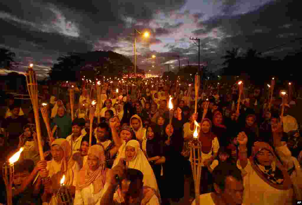 Perempuan Muslim Filipina membawa obor dalam demonstrasi di selatan Filipina yang menyerukan resolusi damai dalam konflik antara pasukan Malaysia dan kelompok bersenjata Filipina di negara bagian Sabah, Kalimantan (6/3). 