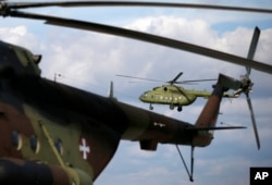 FILE - A Serbian transport helicopter with mixed crew performs during the joint Russian-Serbian military exercises BARS (Brotherhood of Aviators of Russia and Serbia) 2016, at the military airport Batajnica, near Belgrade, Serbia, Oct. 13, 2016.