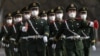 戴着口罩的中国武警士兵走过北京街头。（资料照）