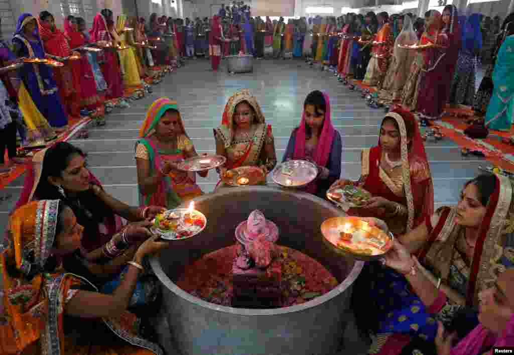 Para perempuan Hindu melakukan ritual &quot;Aarti&quot; mengelilingi sebuah patung kecil (yang melambangkan Dewa Shiwa) pada festival keagamaan di Ahmedabad, India.