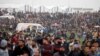 Palestinians are seen gathered during a protest marking Land Day and the first anniversary of a surge of border protests, at the Israel-Gaza border fence east of Gaza City, March 30, 2019. 