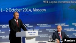 Russia's President Vladimir Putin (L) speaks during the VTB Capital "Russia Calling!" Investment Forum in Moscow, Oct. 2, 2014.