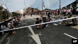 Protesters sit under a canopy at an intersection on a main road occupied by protesters in the Mong Kok area in Hong Kong, Tuesday, Oct. 7, 2014. 