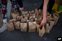 Young volunteers from Lion's Heart, a nonprofit community service organization, prepare sack lunches for homeless people in Dana Point, California, Dec. 21, 2017.
