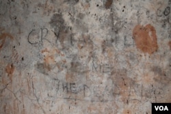 Graffiti on the wall of a dungeon in Buganda Lubiri Palace in Kampala, once used for torturing prisoners. (H. Athumani for VOA)
