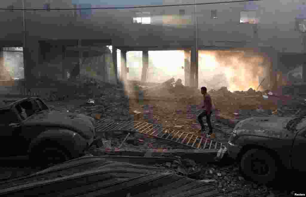 Người Palestine kiểm tra thiệt hại tại một s&acirc;n vận động b&oacute;ng đ&aacute; sau vụ kh&ocirc;ng k&iacute;ch của Israel v&agrave;o Gaza City, ng&agrave;y 19/11/2012. 