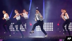 South Korean rapper PSY, in checkered jacket, performs "Gentleman" in a concert entitled "Happening," Seoul, April 13, 2013.