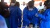 FILE - Health care workers from the World Health Organization prepare to give an Ebola vaccination to a front-line aid worker in Beni, Democratic Republic of the Congo, Aug 10, 2018. 