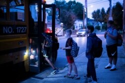 Eliot Miller dan siswa lainnya berjalan ke bus sekolah pada hari pertama sekolah di Louisville, Kentucky, AS, 11 Agustus 2021. (Foto: REUTERS/Amira Karaoud)
